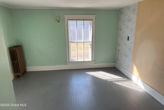 empty room featuring radiator and wood finished floors