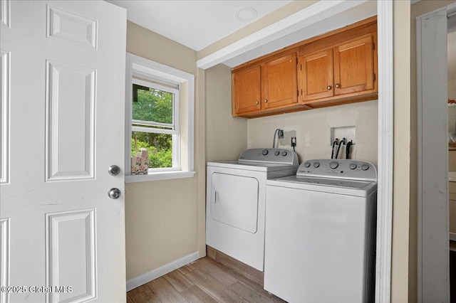 458 Central Ave, Niskayuna, NY 12304 - laundry room with cabinet space, washer and clothes dryer, light wood finished floors, and baseboards