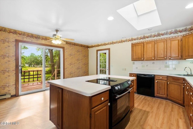 104 Euclid Ave, Altamont, NY 12009 - kitchen with black appliances, wallpapered walls, a skylight, light wood-style floors, and a center island