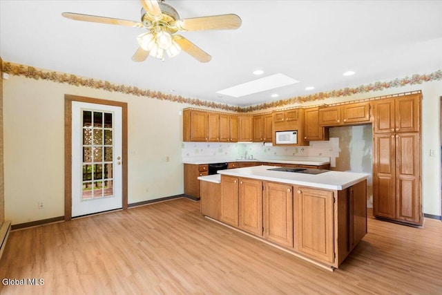 104 Euclid Ave, Altamont, NY 12009 - kitchen with black appliances, a skylight, light countertops, light wood-style floors, and recessed lighting