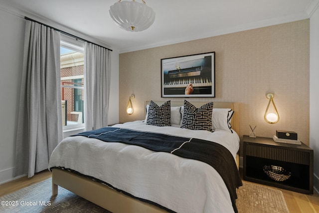 bedroom featuring crown molding, baseboards, and wood finished floors