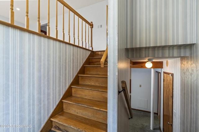 stairway with visible vents, wallpapered walls, and carpet