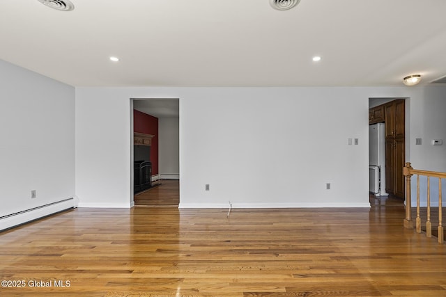 unfurnished room featuring baseboards, recessed lighting, baseboard heating, and light wood-type flooring
