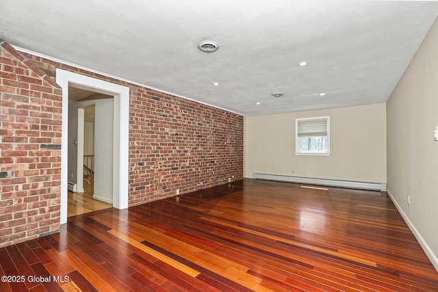 spare room featuring recessed lighting, brick wall, wood-type flooring, baseboards, and baseboard heating