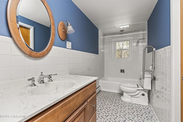 full bath featuring tile walls, vanity, toilet, baseboard heating, and  shower combination