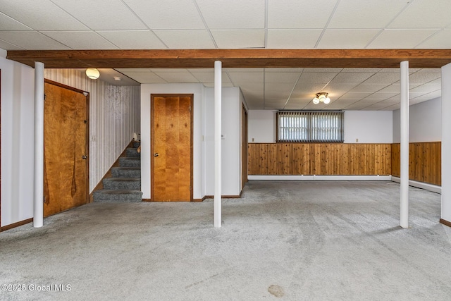 basement with wood walls, stairs, wainscoting, and carpet floors