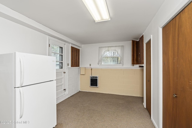 kitchen with carpet, heating unit, a wealth of natural light, and freestanding refrigerator