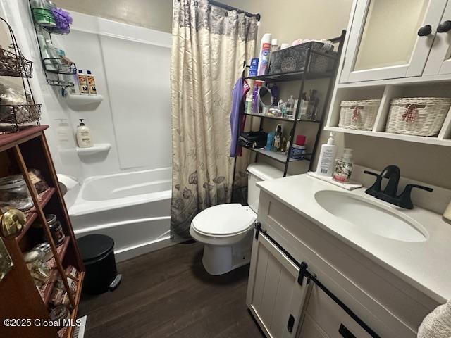 2543 Moriah Rd, Moriah, NY 12960 - bathroom featuring toilet, wood finished floors, shower / bath combo with shower curtain, and vanity