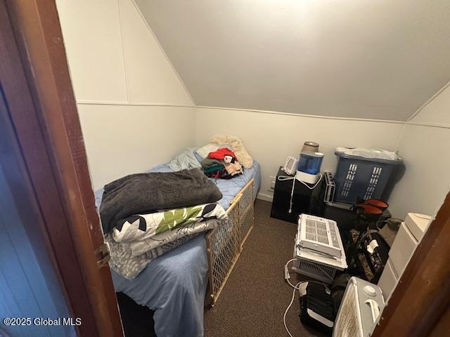 2543 Moriah Rd, Moriah, NY 12960 - bedroom featuring dark carpet and vaulted ceiling