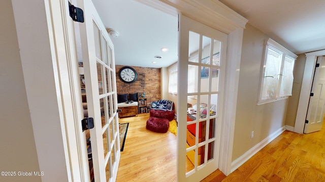 hallway featuring french doors, baseboards, and wood finished floors