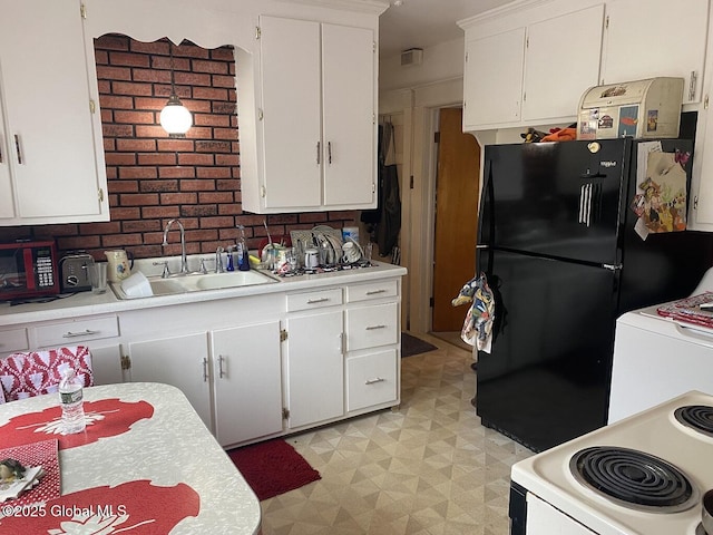 kitchen with a sink, freestanding refrigerator, light floors, light countertops, and white range with electric stovetop