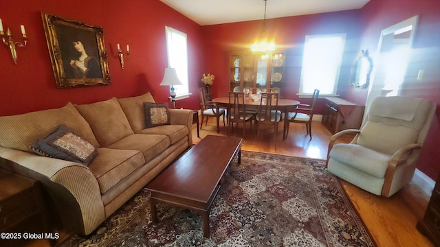 living room featuring a chandelier, wood finished floors, and plenty of natural light