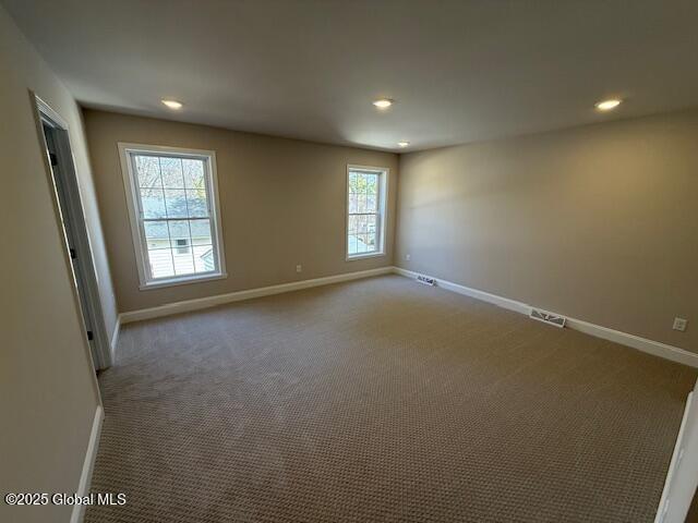 unfurnished room featuring recessed lighting, visible vents, baseboards, and carpet floors