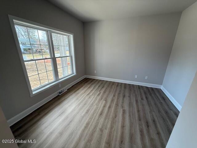 unfurnished room featuring baseboards and wood finished floors