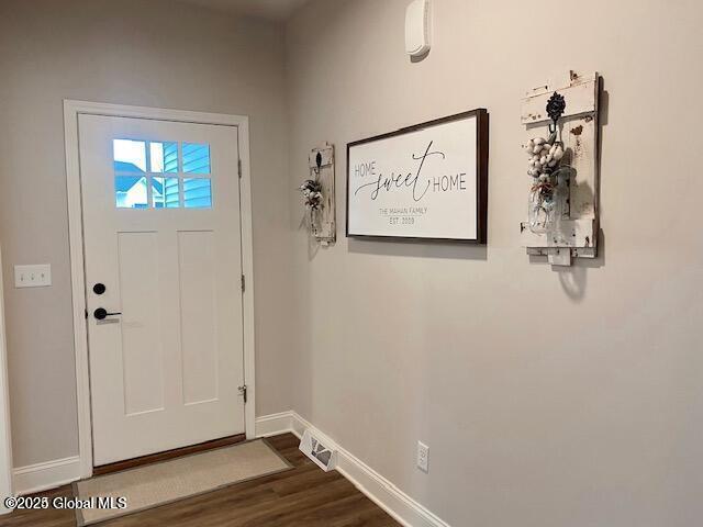 foyer featuring visible vents, baseboards, and dark wood finished floors