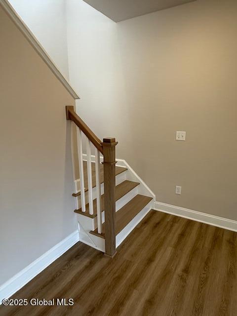 stairway featuring baseboards and wood finished floors