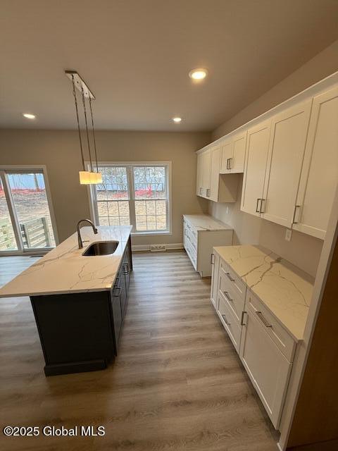 kitchen featuring a sink, light wood-style flooring, recessed lighting, and a wealth of natural light