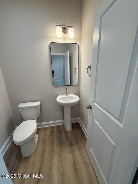 bathroom featuring baseboards, toilet, and wood finished floors