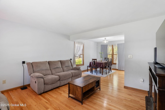 living room featuring baseboards and light wood-style flooring