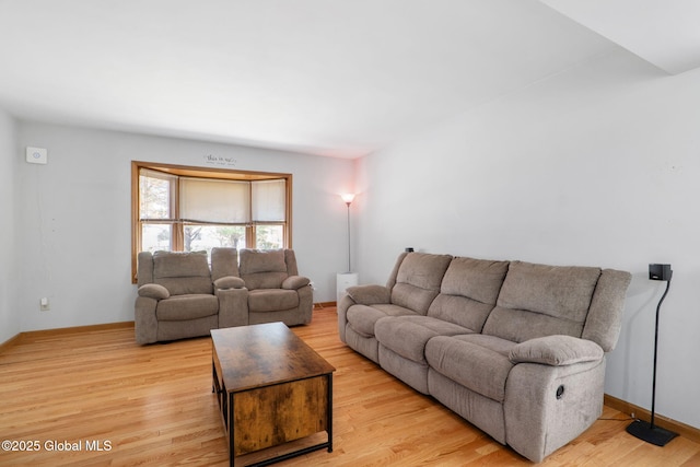 living area featuring baseboards and light wood-style flooring