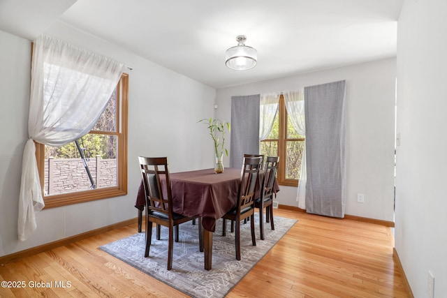 dining space featuring baseboards and light wood-type flooring