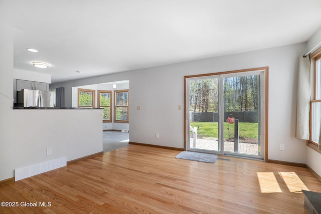 interior space featuring visible vents, light wood-style floors, and plenty of natural light