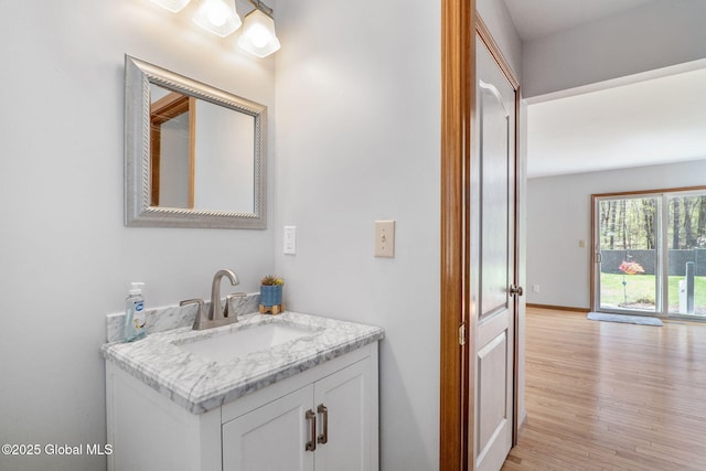 bathroom with baseboards, wood finished floors, and vanity