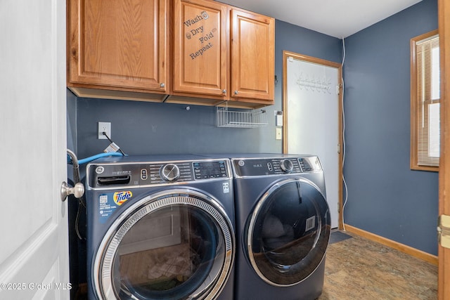 laundry area featuring baseboards, cabinet space, and washer and dryer