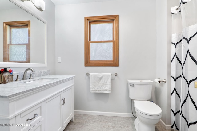 full bathroom featuring toilet, baseboards, and vanity
