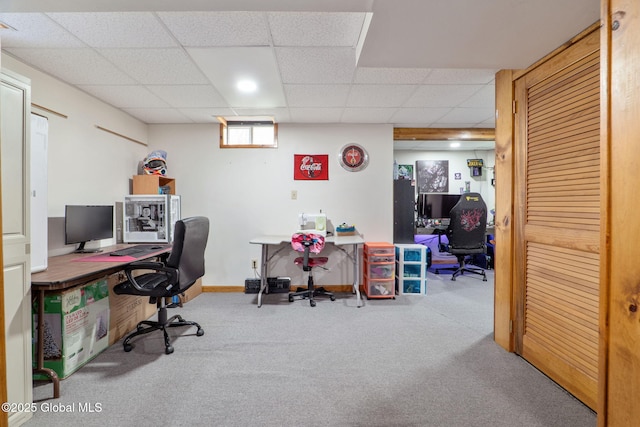 carpeted office space with baseboards and a drop ceiling