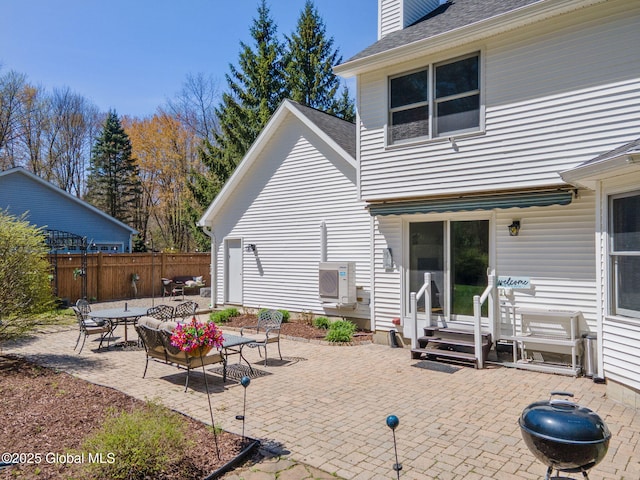 rear view of property featuring a chimney, roof with shingles, a patio area, fence, and entry steps