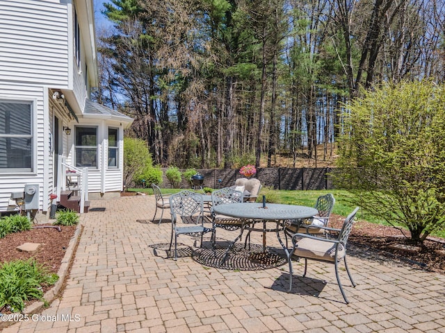 view of patio featuring outdoor dining area, fence, and entry steps