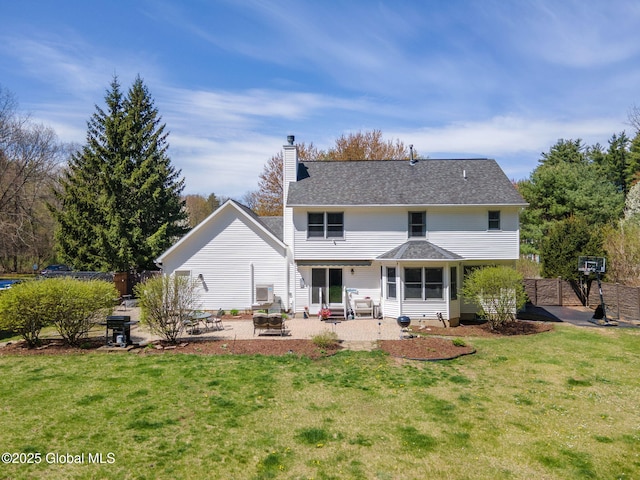 back of house featuring fence, a chimney, a lawn, a patio, and a fire pit