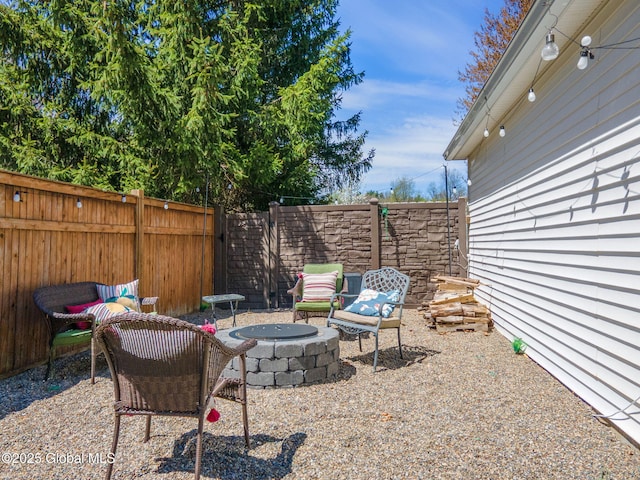 view of yard featuring a fenced backyard and a fire pit