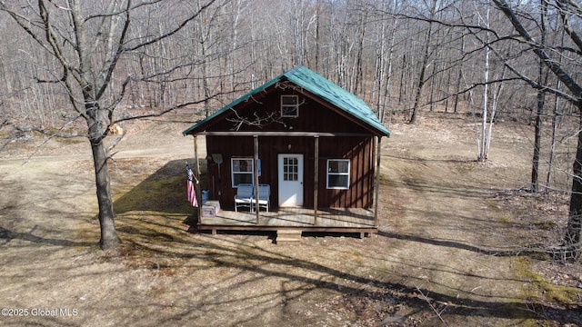 view of outdoor structure with a view of trees and an outbuilding