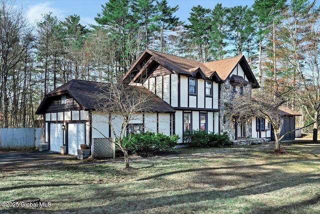 view of front of home featuring fence, a front lawn, and a garage