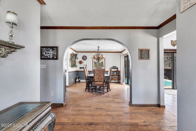 dining area with arched walkways and a textured ceiling