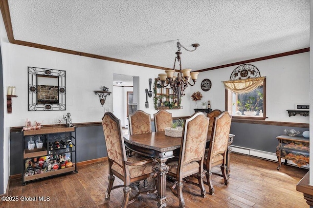 dining space featuring a textured ceiling, crown molding, hardwood / wood-style flooring, and an inviting chandelier