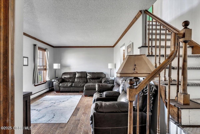 living room with stairs, wood finished floors, a textured ceiling, a baseboard heating unit, and ornamental molding