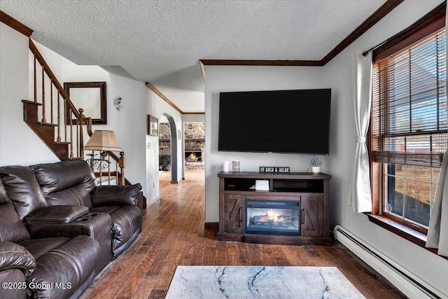 living area featuring a baseboard heating unit, arched walkways, a textured ceiling, crown molding, and hardwood / wood-style flooring