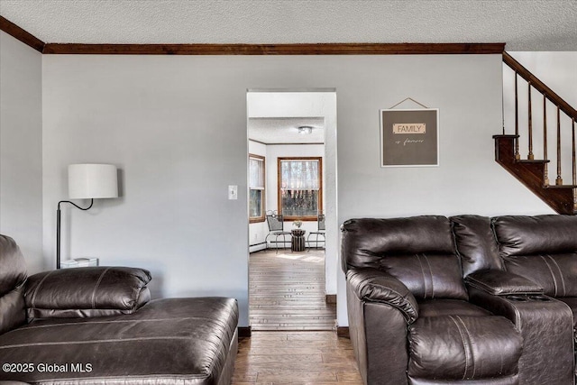 living area with stairway, a textured ceiling, ornamental molding, and wood-type flooring