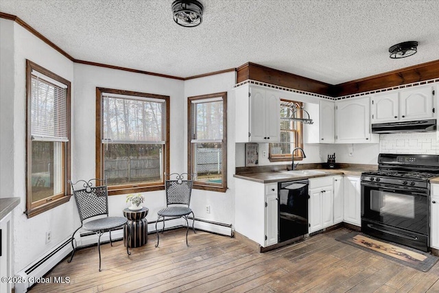 kitchen featuring white cabinets, a sink, under cabinet range hood, and black appliances