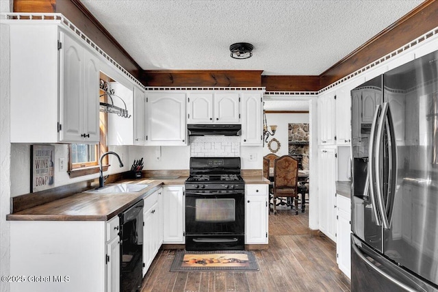 kitchen with under cabinet range hood, a sink, a textured ceiling, and black appliances