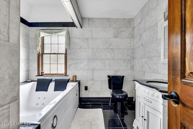 bathroom with tile patterned floors, a textured ceiling, vanity, a jetted tub, and toilet