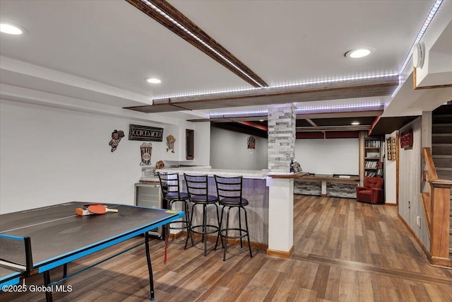 interior space with recessed lighting, wood finished floors, stairway, and bar area