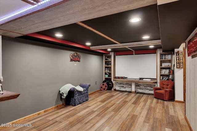 home theater featuring recessed lighting, wood finished floors, built in shelves, and baseboards