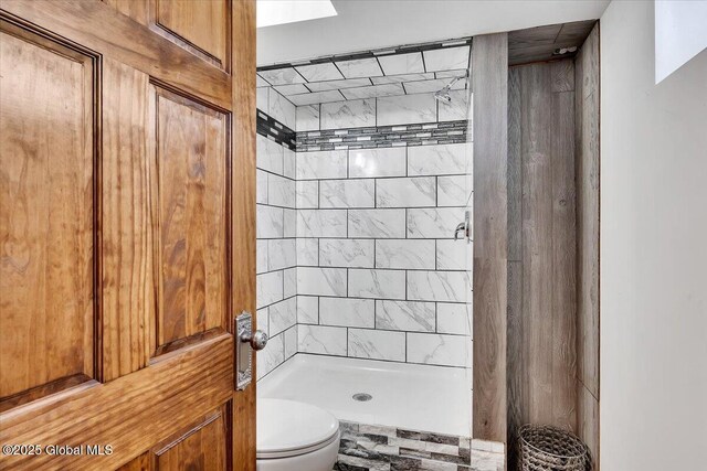bathroom with a shower stall and toilet