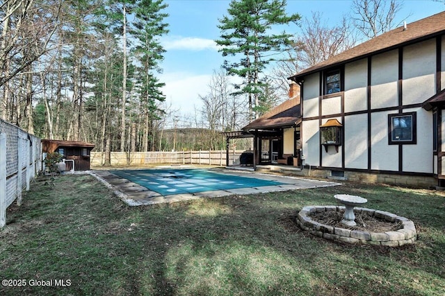view of swimming pool featuring a patio area, a storage shed, a fenced backyard, a yard, and a fenced in pool