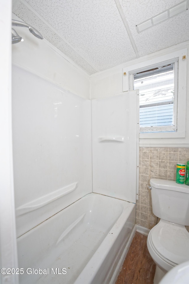 full bath with a washtub, visible vents, walk in shower, wood finished floors, and toilet