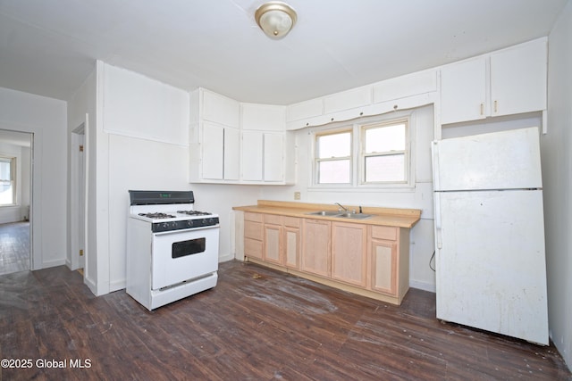 kitchen featuring dark wood finished floors, baseboards, white appliances, and a sink